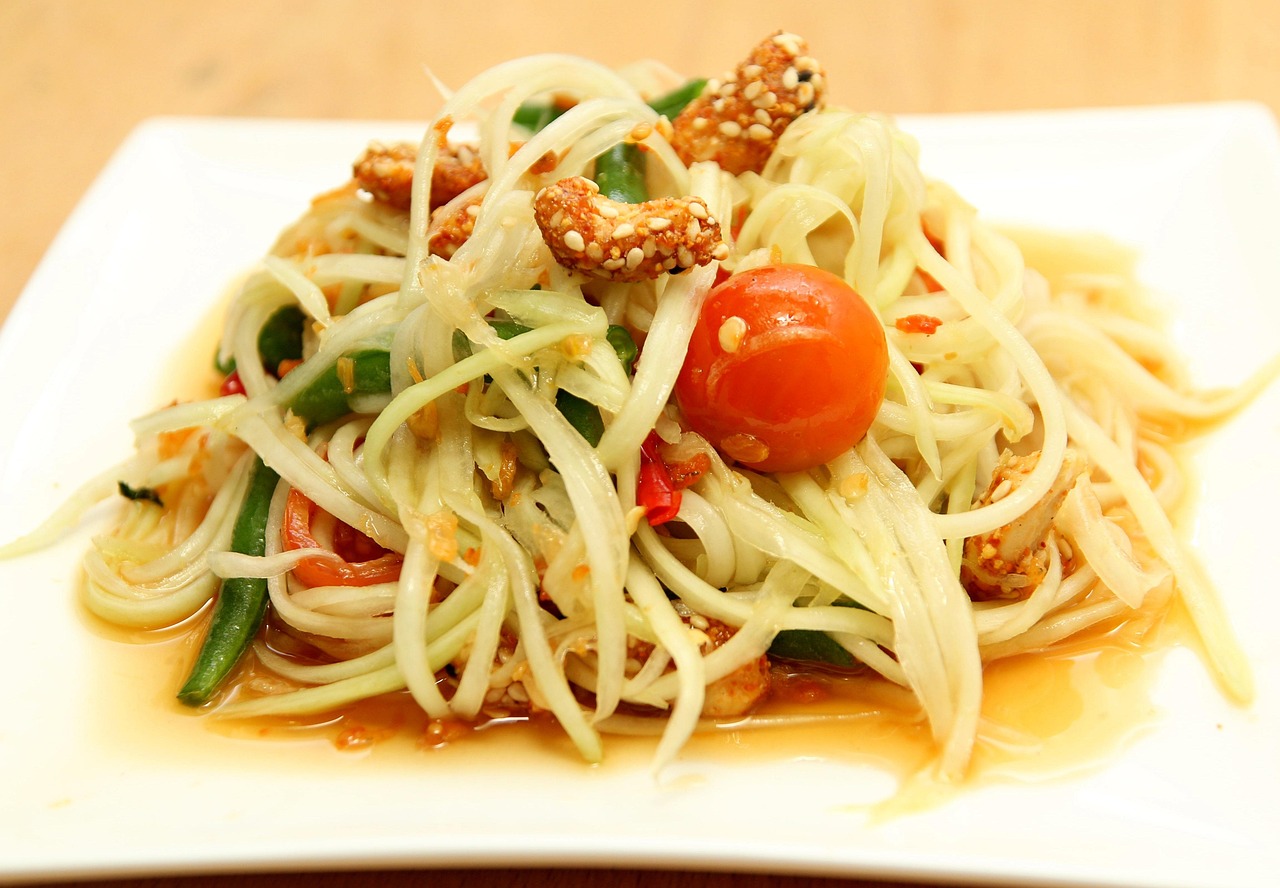 A plate of green papaya salad with fresh vegetables